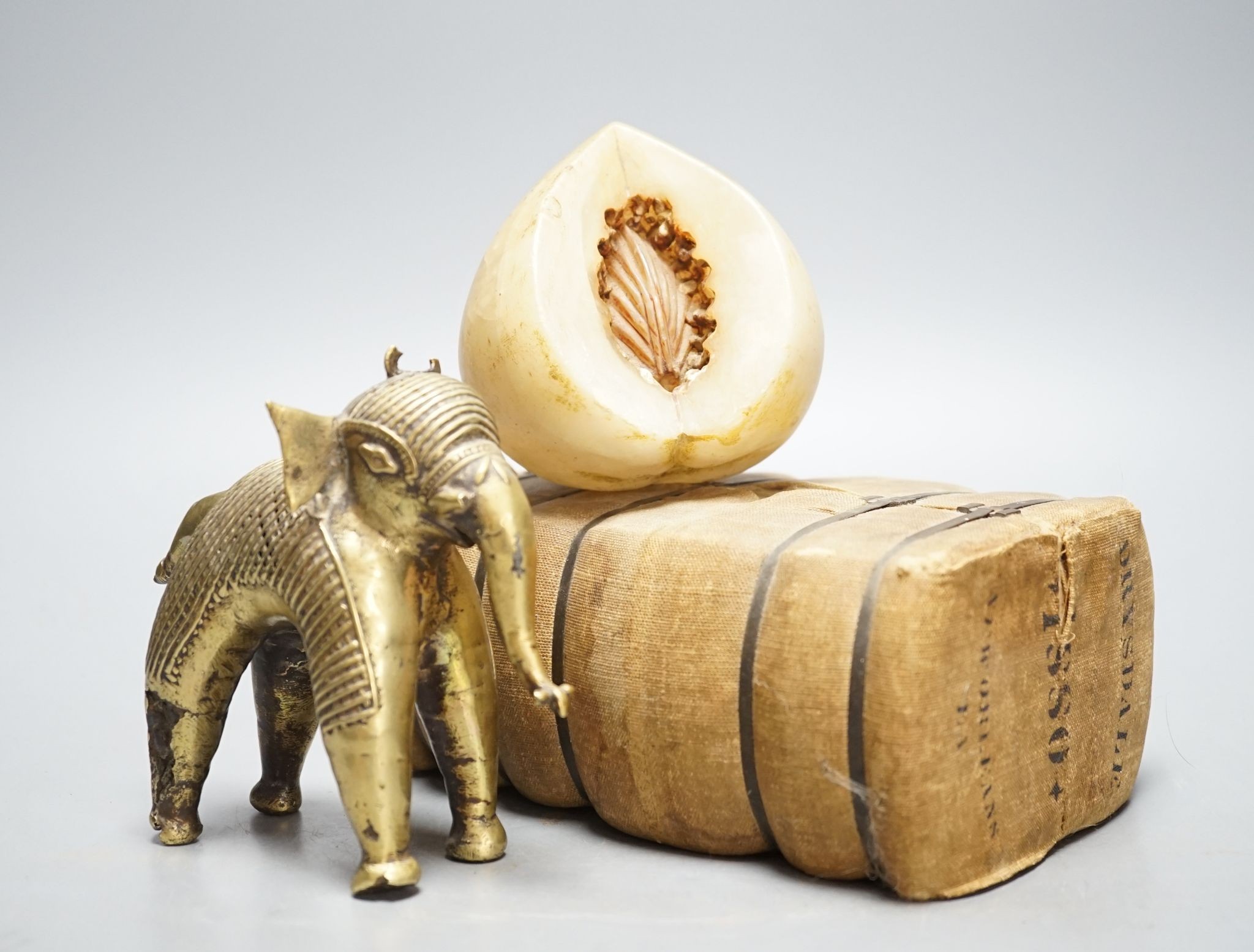 An alabaster fruit carving, a Benin brass elephant and salesman's model of a bale of Drysdale cotton, 18 cm